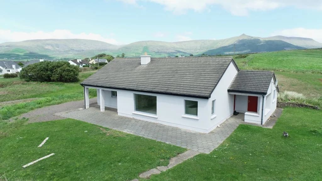 White bungalow with a red door before the rebuild