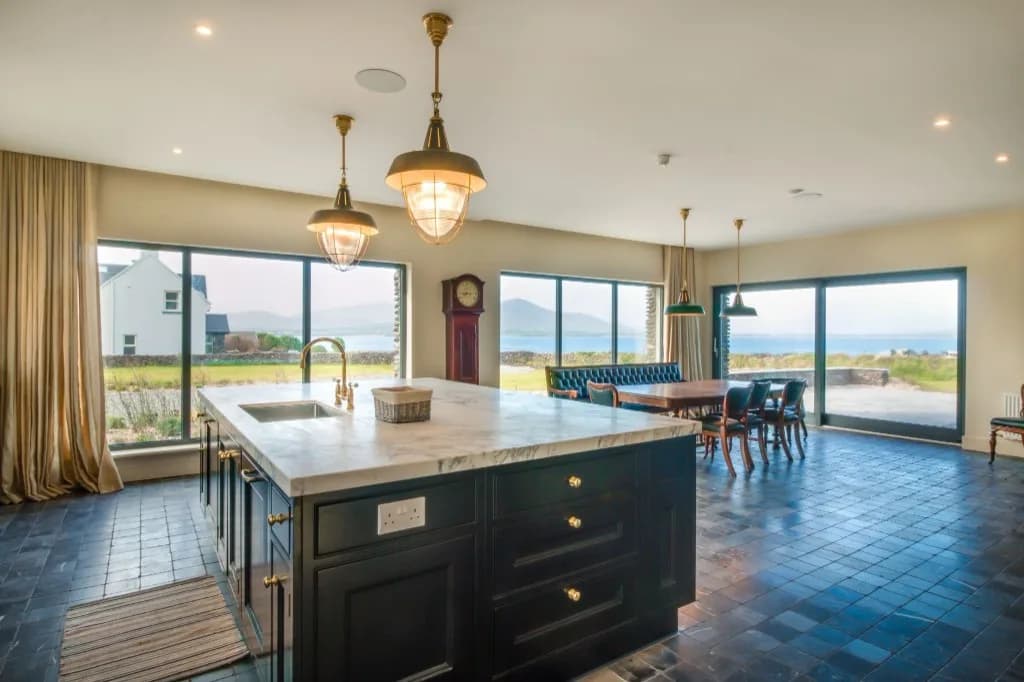 Kitchen and dining room with marble island and windows over the water