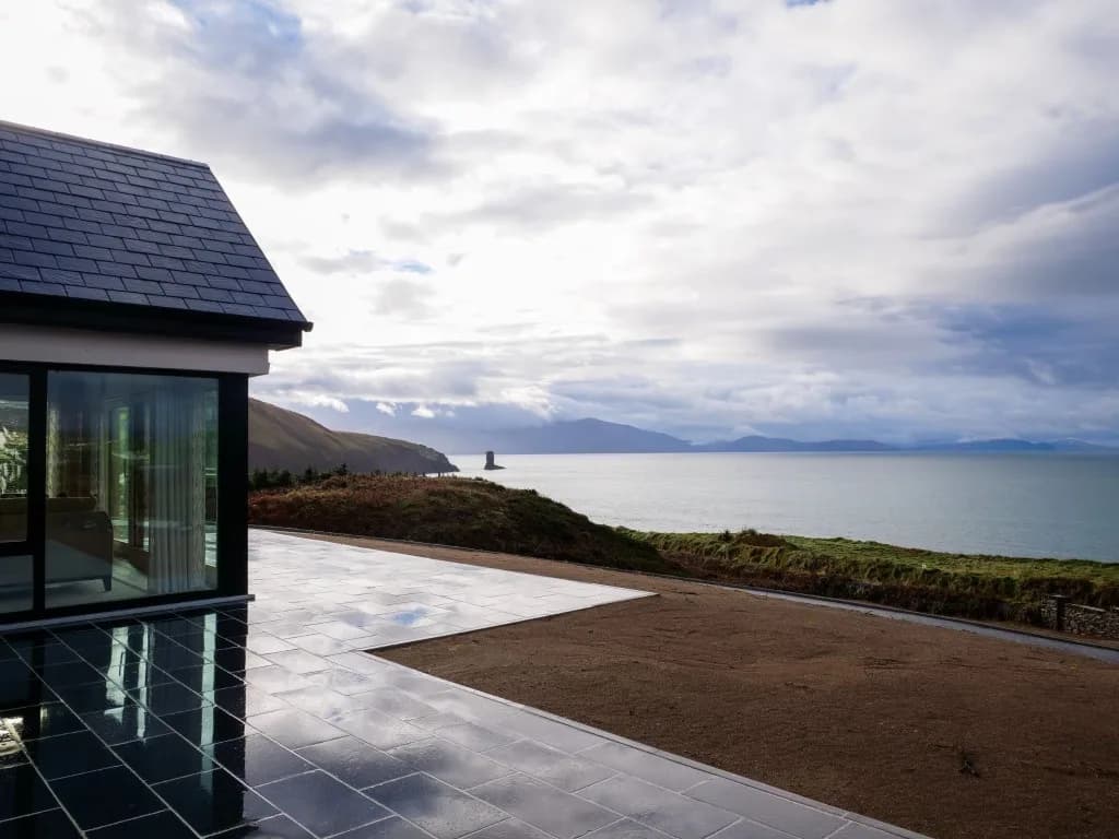 A glazed room opening onto a terrace above the Atlantic