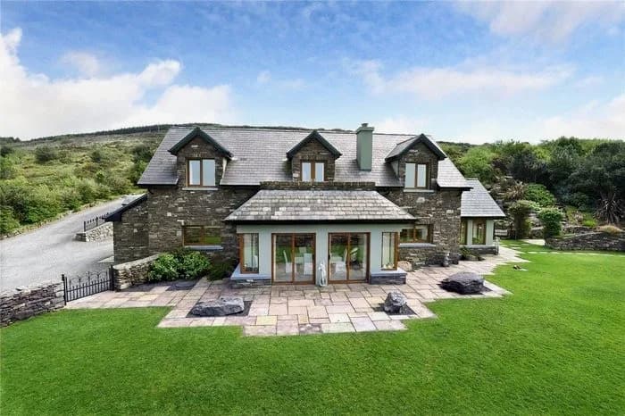 Stone house with a glazed extension and lawn